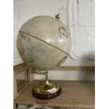 A reproduction 12 inch diameter world globe on brass and turned wood stand