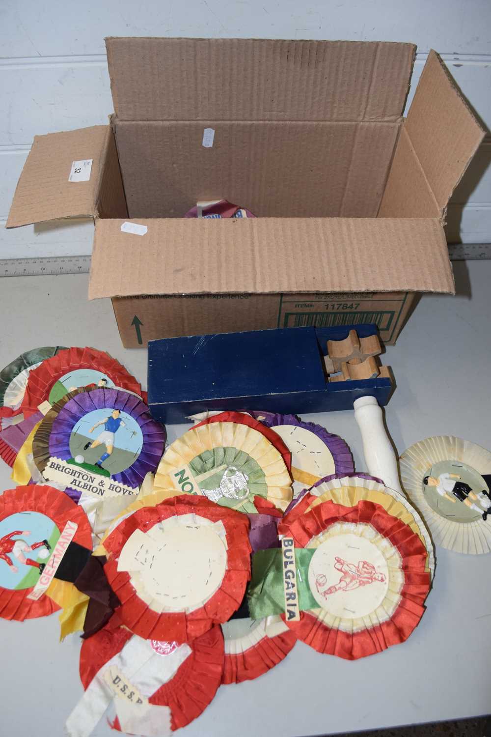 Box of various vintage homemade football rosettes and a football rattle