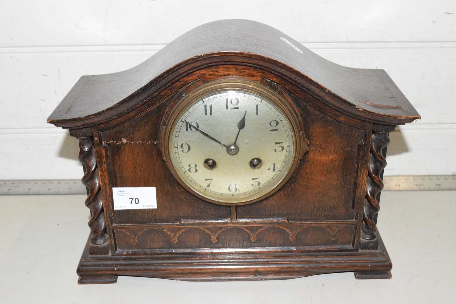 An oak cased mantel clock with barley twist supports