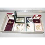 A box of various assorted costume jewellery to include horse brooches