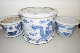 Three 20th Century Chinese blue and white jardinieres decorated with dragons, the largest 40cm