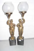 A pair of table lamps formed as figures holding torchairs set on polished stone bases
