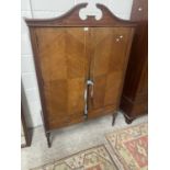 Reproduction mahogany veneered two door cupboard with arched pediment