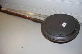 A copper bed warming pan