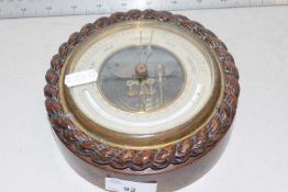 A small barometer in oak case with rope carved decoration