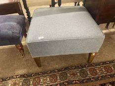 A blue upholstered square footstool