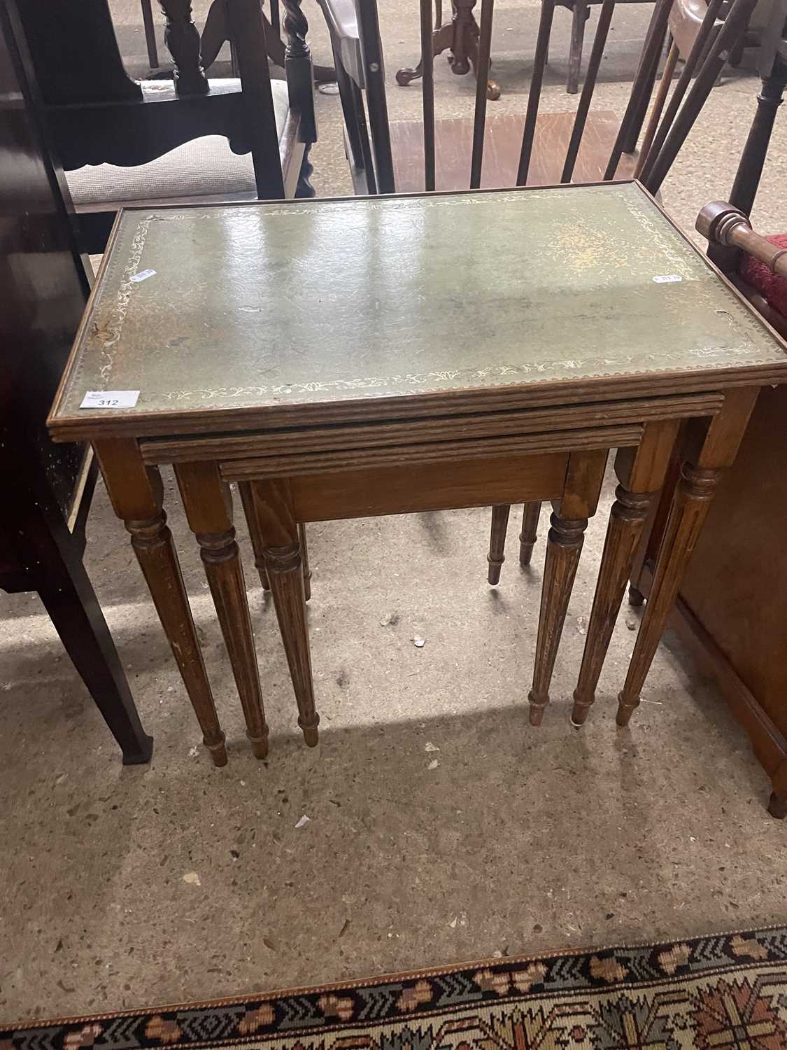 A nest of three tables with leather tops