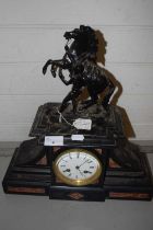 A French black slate and marble mounted mantel clock with applied metal marley horse detail