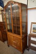 An early 20th Century walnut veneered arch top display cabinet with cupboard base, 197cm wide
