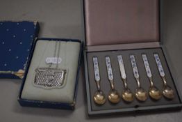 Cased set of enamel coffee spoons together with miniature Estee pendant formed as a handbag