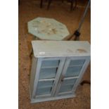 Small painted folding table together with a glazed two door cabinet