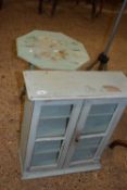 Small painted folding table together with a glazed two door cabinet