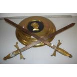 Two decorative swords together with a brass wall plaque