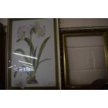 A picture of lilies together with an empty gilt frame