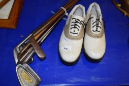Pair of golf shoes and six golf clubs