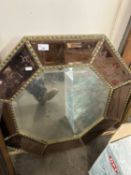 An octagonal wall mirror with bronzed bevelled engraved panels and gilt framing