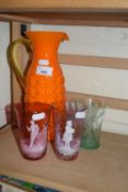 A pair of cranberry glass white overlay tumblers together with a mid 20th Century orange glass jug