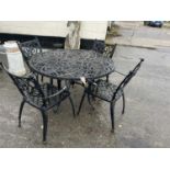 A cast metal garden table and four chairs