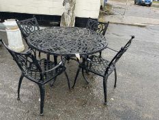 A cast metal garden table and four chairs