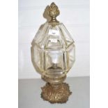 A brass ceiling light fitting with faceted clear glass shade