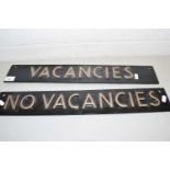 Two metal double sided signs marked 'Vacancies' and 'No Vacancies'