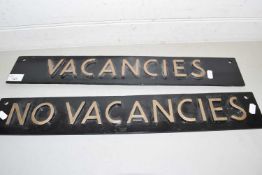 Two metal double sided signs marked 'Vacancies' and 'No Vacancies'