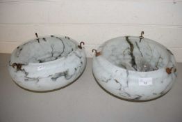 A pair of circular marbled glass light shades