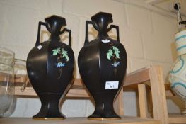 A pair of black and floral decorated vases