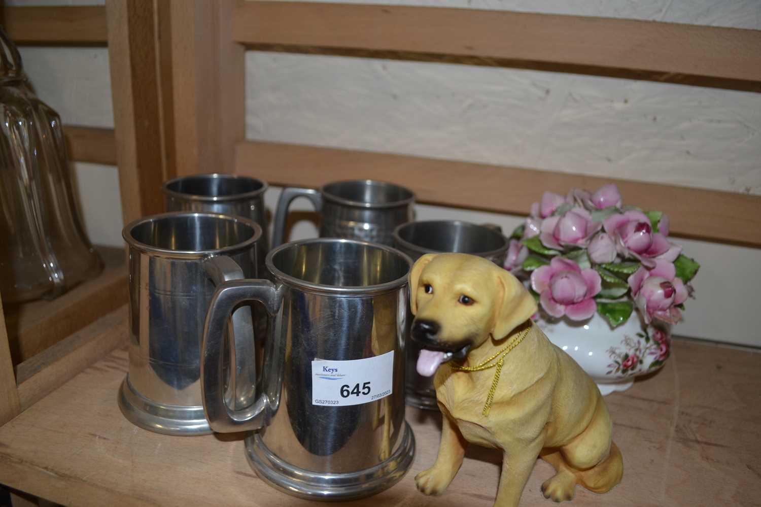 Five pewter tankards together with a model labrador and a ceramic vase of flowers