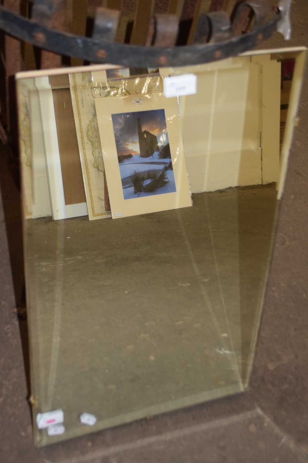 An unframed wall mirror with bevelled edge glass