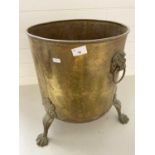 Large brass cylindrical three footed jardiniere with lion mask handles