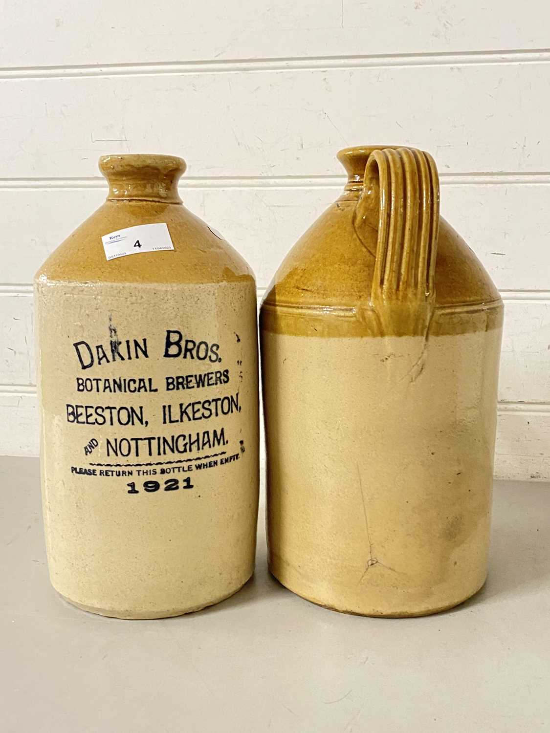 Two stone ware flagons, one marked Dakin Bros