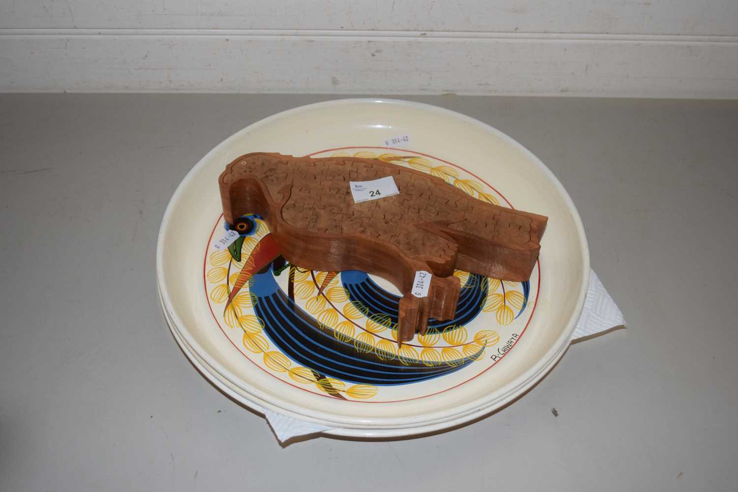 Set of three painted metal serving trays from Tanzania together with a wooden eagle shaped jigsaw