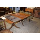 Mahogany twin pedestal dining table set on turned columns with tripod bases, paw feet and brass