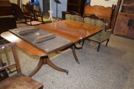 Mahogany twin pedestal dining table set on turned columns with tripod bases, paw feet and brass