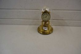 Kundo brass anniversary clock with floral decorated dial with Arabic numerals set under a glass