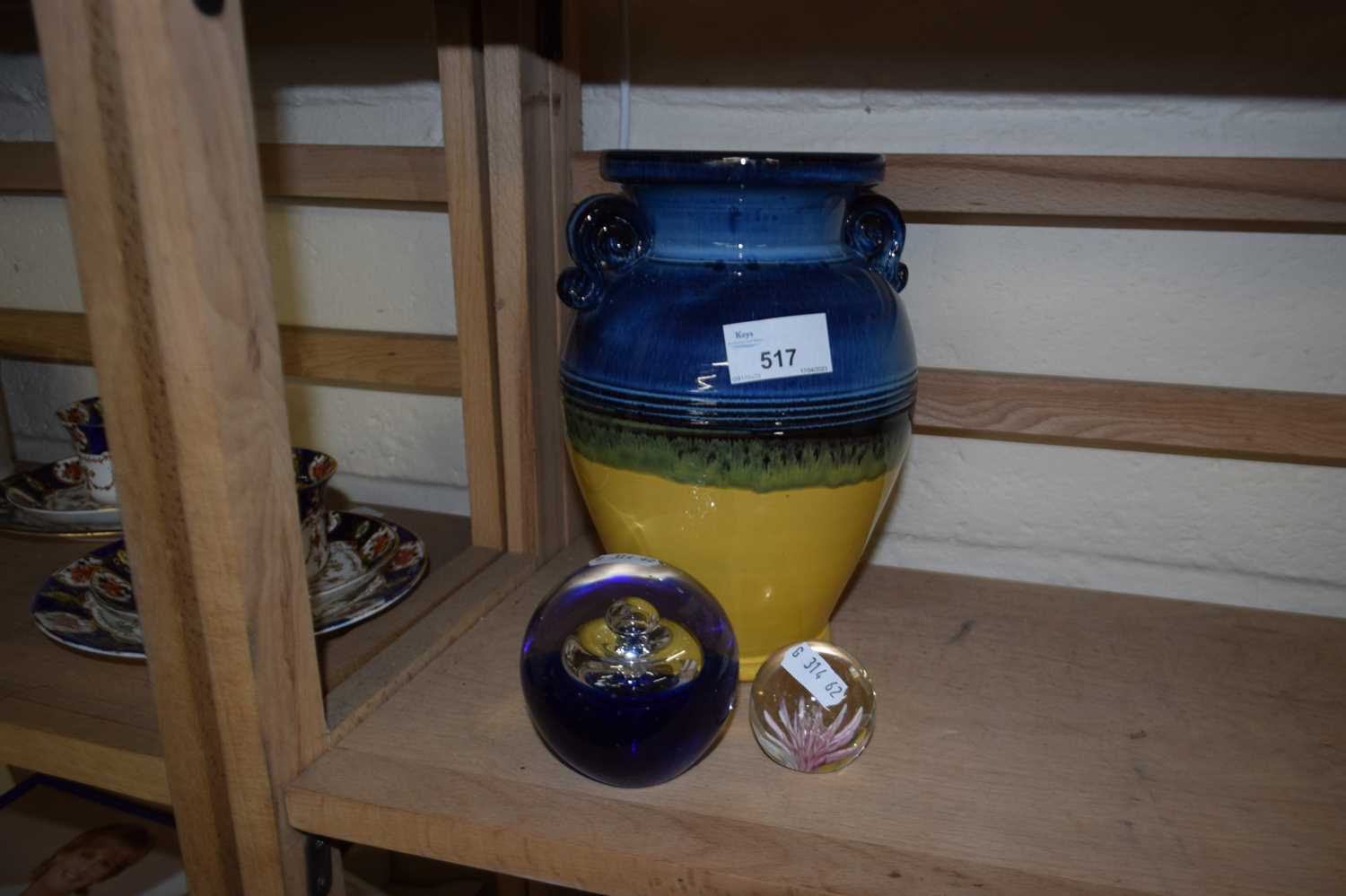 Blue, green and yellow glazed terracotta vase together with two glass paperweights