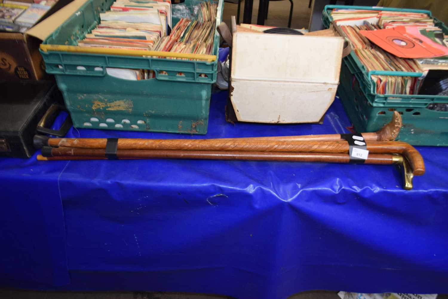 Four walking sticks, two with brass heads, one of a carved pheasant and another