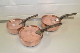 Set of three small copper lidded saucepans