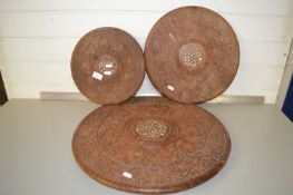 Group of three Far Eastern hardwood circular table tops with carved decoration, largest 51cm