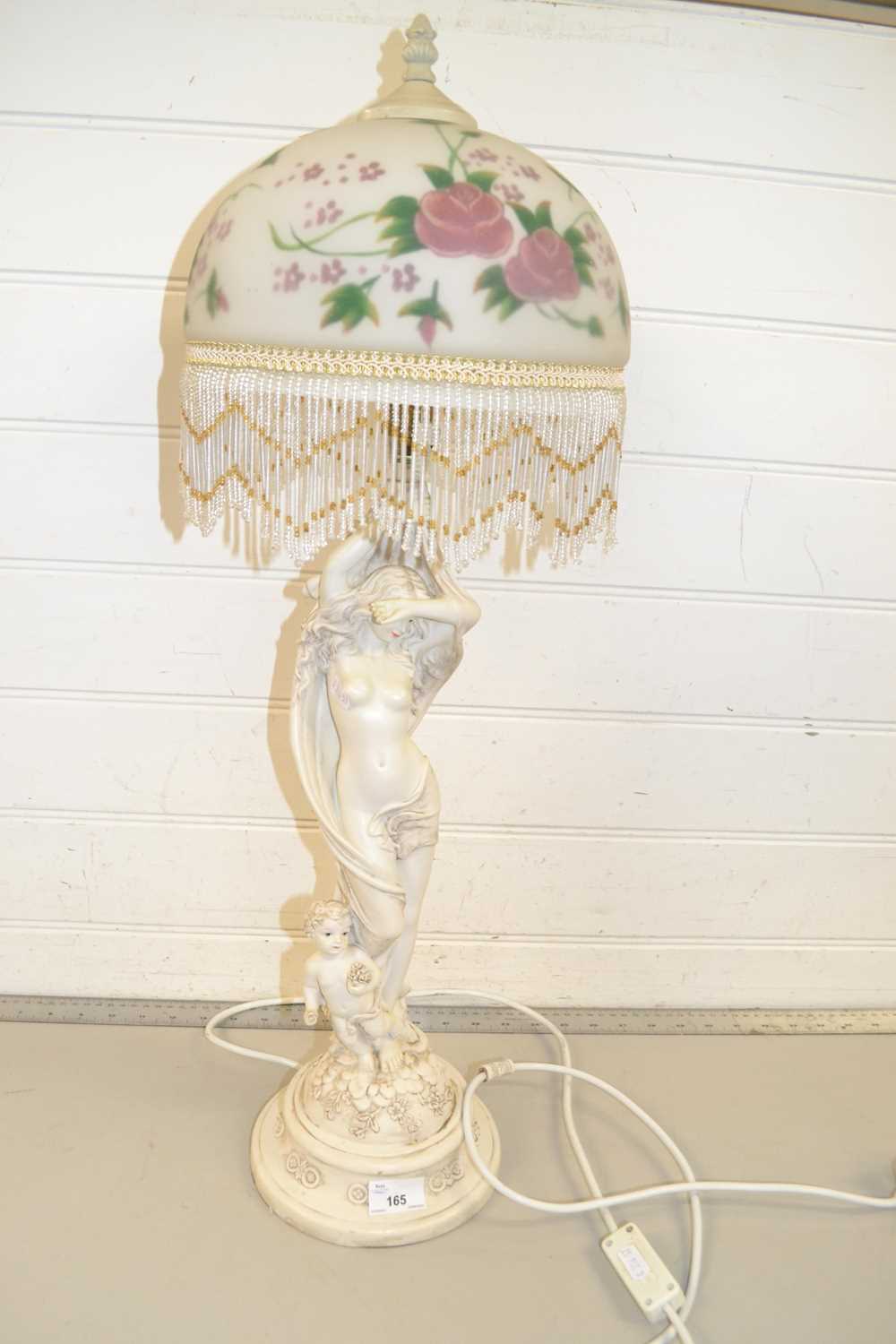 A modern figural table lamp with floral glass shade