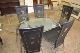 Modern oval dining table with bevelled clear glass top together with five metal framed chairs