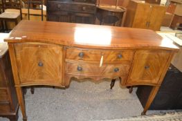 Reproduction mahogany veneered serpentine front sideboard raised on tapering legs with spade feet,