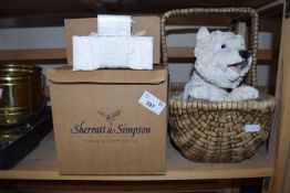 Resin model of a West Highland Terrier in a basket together with other similar models