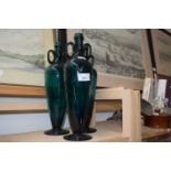 Three dark green glass bottle vases