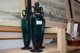 Three dark green glass bottle vases