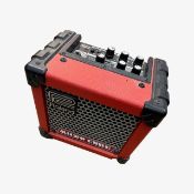 A Roland Micro Cube practice guitar amp in red