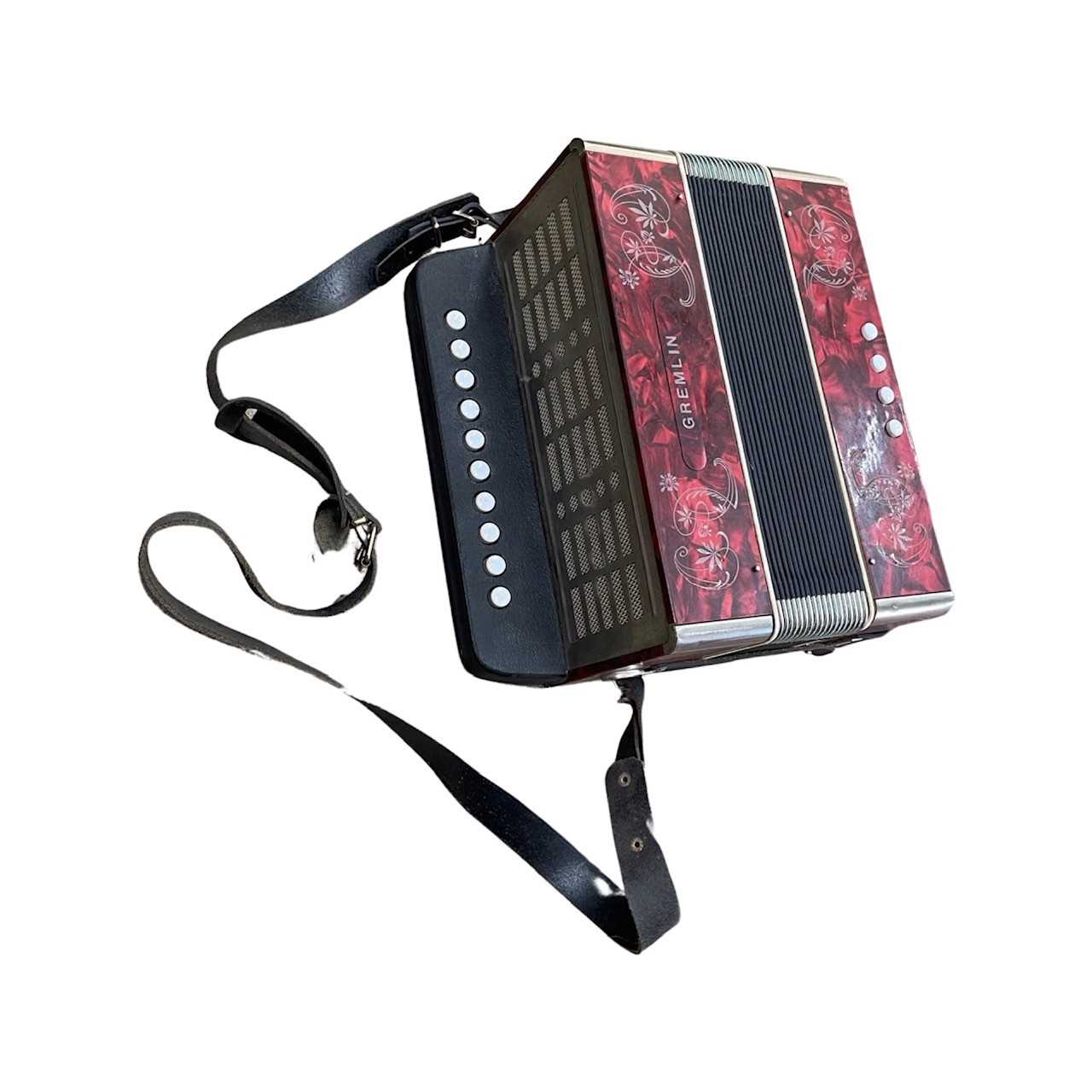 A Gremlin accordion with etched floral details on a marbled deep red background