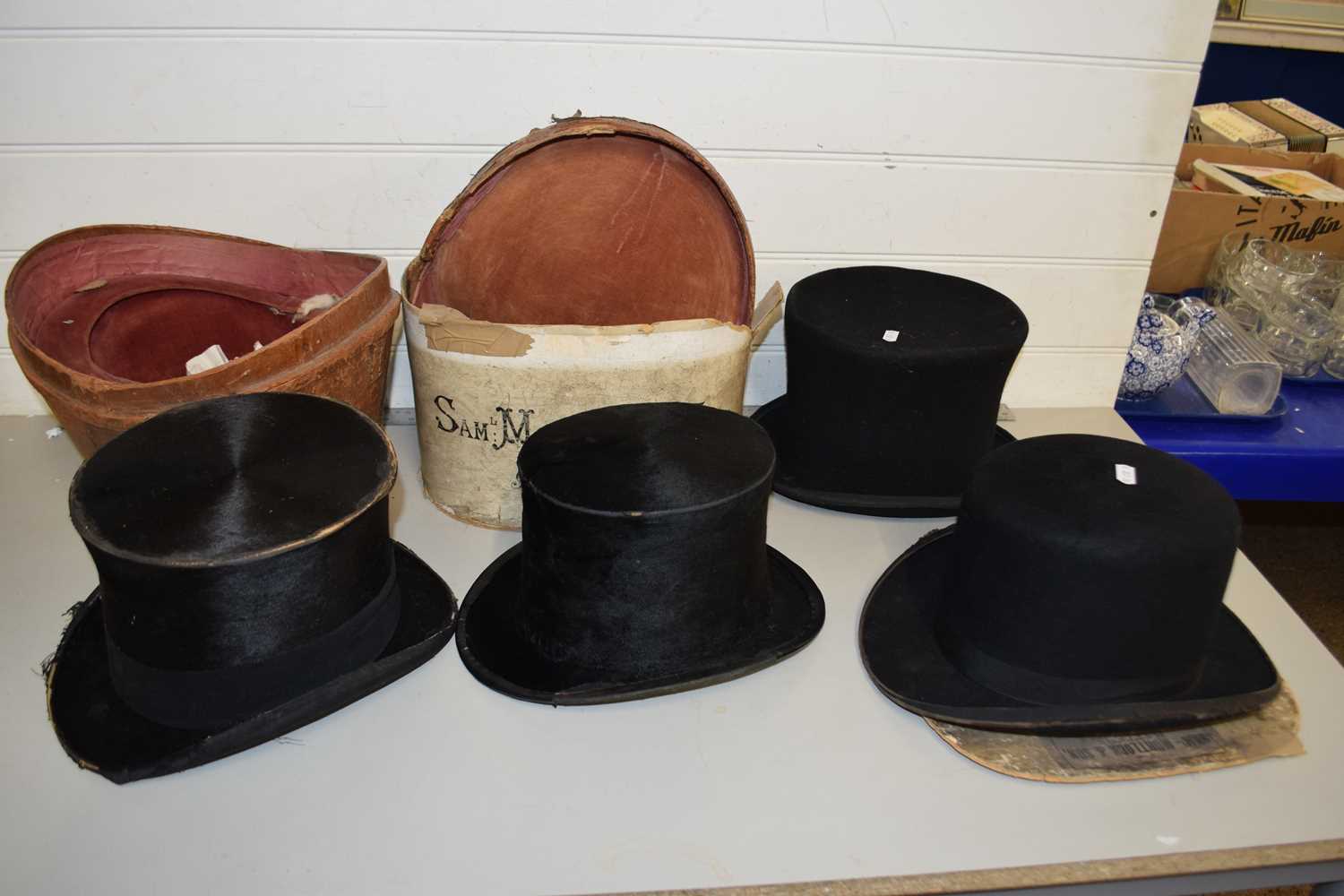 A collection of four various top hats, all showing significant surface wear