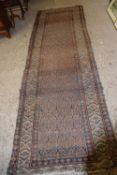 Antique Middle Eastern wool runner carpet with a large central geometric panel surrounded by a three